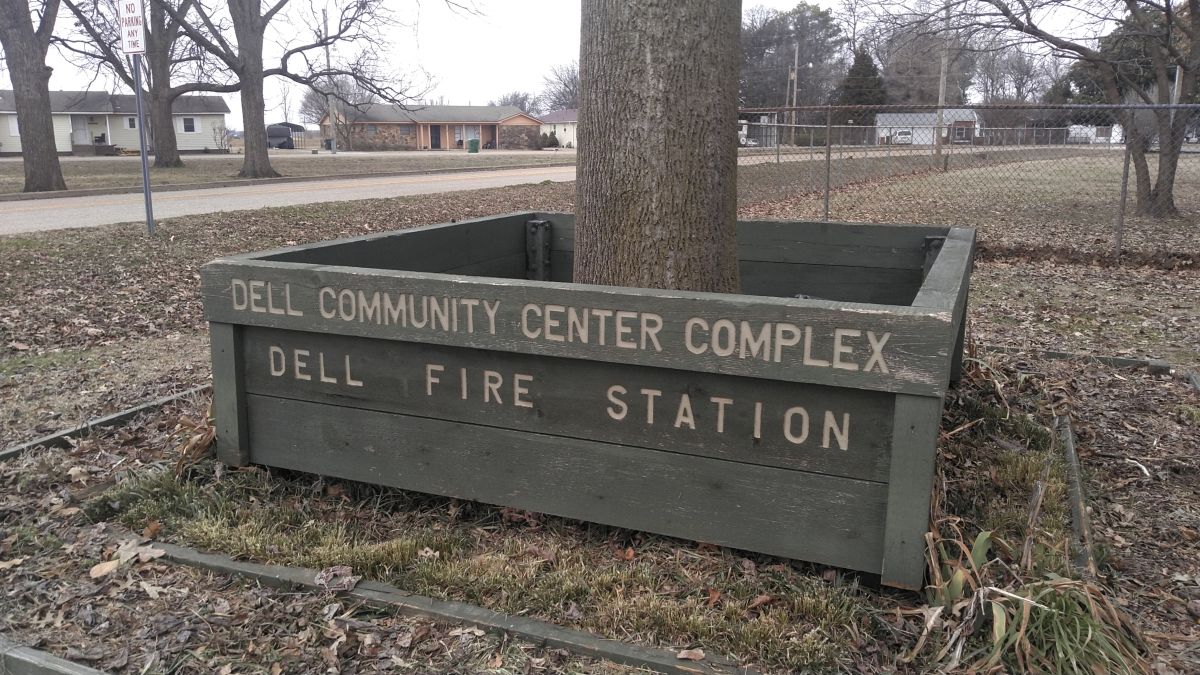 Planter with a tree in it that says Dell Community Center Complex and Dell Fire Station