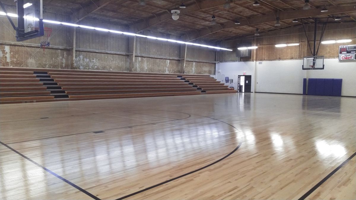 Dell Gym's basketball court with lights on and bleachers open